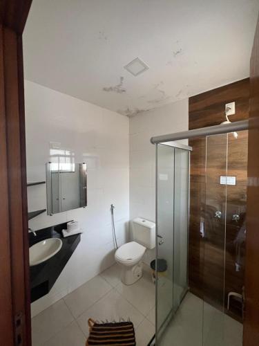 a bathroom with a toilet and a sink at Pousada Portal da Lua in São Thomé das Letras