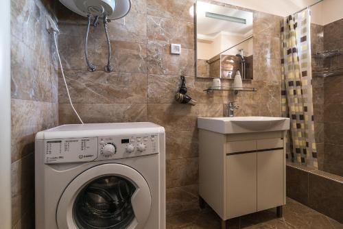 a bathroom with a washing machine and a sink at Sea View Apartments MonteBook in Becici