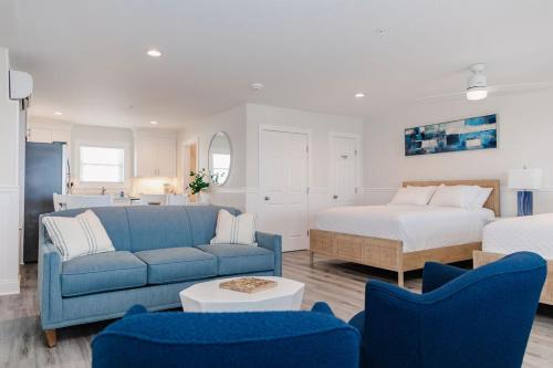 a living room with a blue couch and a bed at 3002 Queen Suite, 3rd Floor Surfside in Surf City