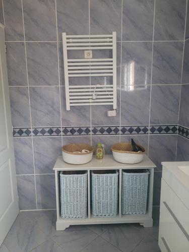 - une salle de bains avec trois paniers sur une étagère dans une chambre dans l'établissement L'Oliviers Country house, à Cadeilhan