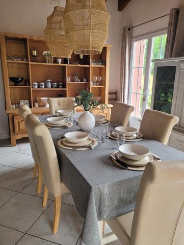 une table à manger avec des chaises et un chiffon bleu dans l'établissement L'Oliviers Country house, à Cadeilhan