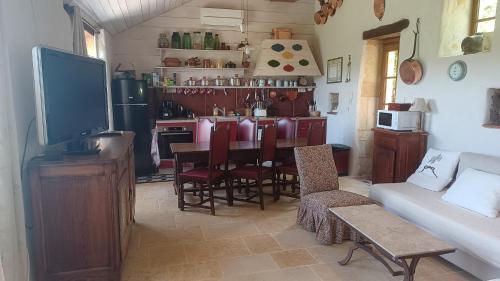 Il comprend un salon doté d'une télévision et d'une table avec des chaises. dans l'établissement la tour de garde, à Saint-Aubin-en-Charollais