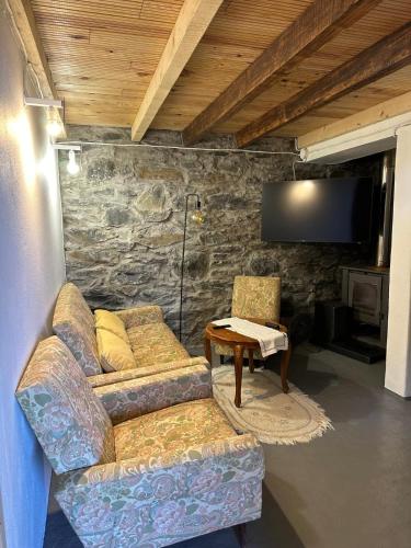 a living room with a couch and a tv at Casa de basalto in Caniço