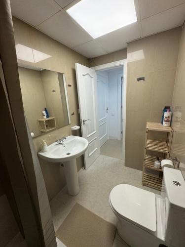 a bathroom with a sink and a toilet and a mirror at Precioso y luminoso apartamento junto al mar y playa en Garrucha 1B in Garrucha