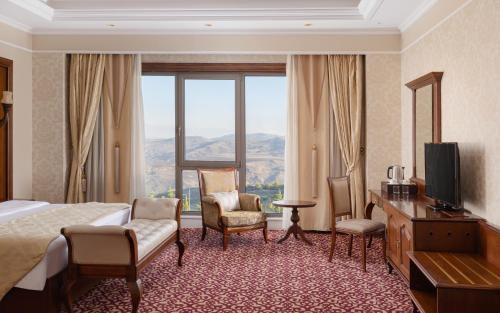 a hotel room with a bed and a large window at Shamakhi Palace Sharadil in Şǝrǝdil