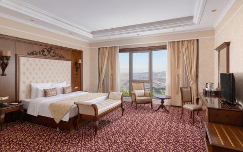a hotel room with a bed and a television at Shamakhi Palace Sharadil in Şǝrǝdil