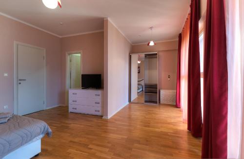 a bedroom with a bed and a dresser with a television at Sea View Apartments MonteBook in Becici