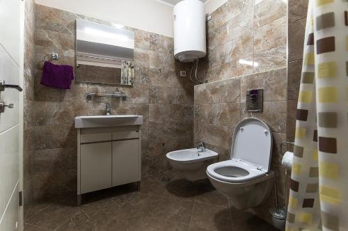 a bathroom with a toilet and a sink at Sea View Apartments MonteBook in Becici