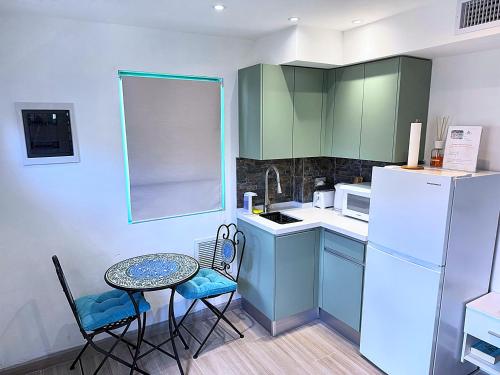 a small kitchen with a table and a white refrigerator at Mary's Boon Beach Resort & Spa in Simpson Bay