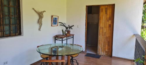 a room with a glass table and a refrigerator at Flat Carvalhos de Aldeia km5 in Recife