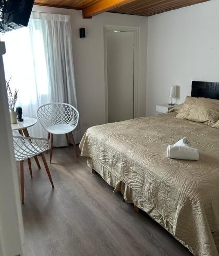 a bedroom with a bed and a table and a chair at Nuevo Hotel del Faro Punta del este in Punta del Este