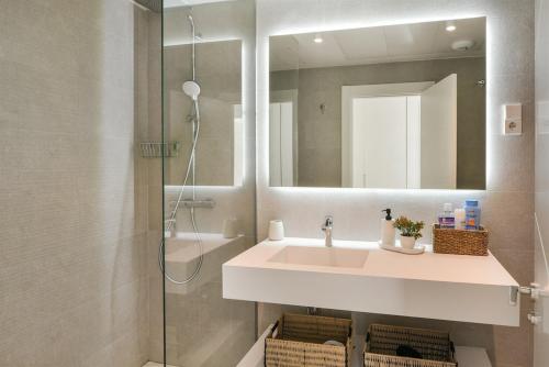 ラ・カラ・デ・ミハスにあるGarden apartment with spa, outdoor pool & parkingの洗面台と鏡付きシャワーを備えたバスルーム