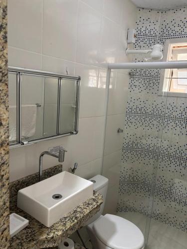 a bathroom with a toilet and a sink and a shower at Casa Branca in Saquarema
