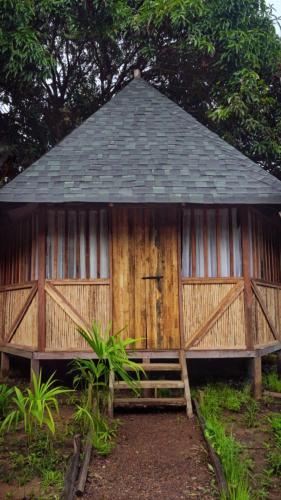 a wooden building with a gate and a roof at PRIMITIVO LODGE & dive center in Bahía Solano