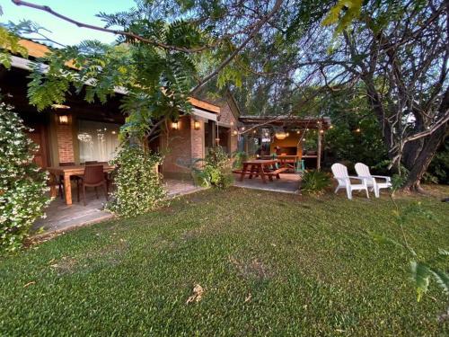 a house with a yard with chairs and a table at CHACRA con VISTA AL CAMPO DE POLO in Pilar