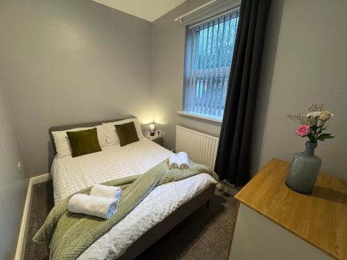 a small bedroom with a bed and a window at Omega Apartment - 3 Bedrooms - Sleeps 5 in Whitehaven