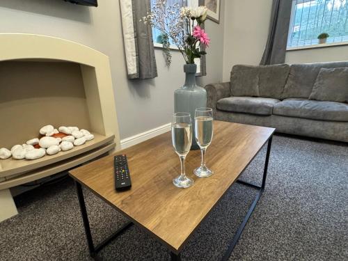 a living room with two wine glasses and a remote control at Omega Apartment - 3 Bedrooms - Sleeps 5 in Whitehaven