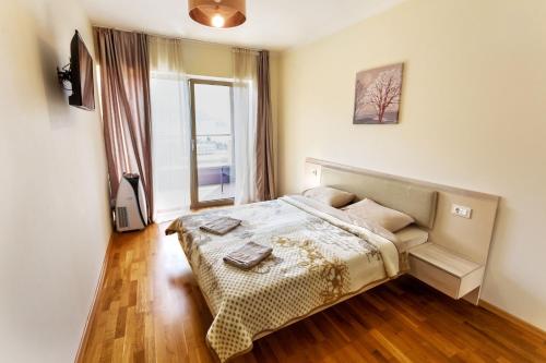 a bedroom with a bed and a large window at Sea View Apartments MonteBook in Becici
