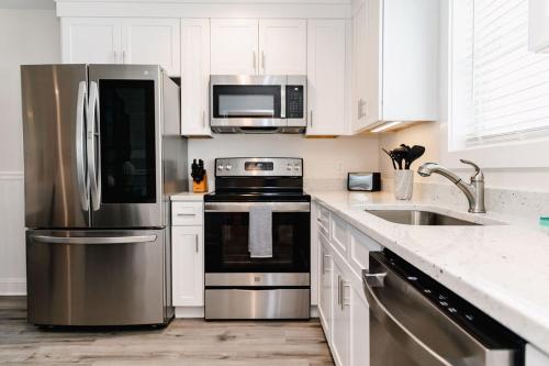 a kitchen with stainless steel appliances and white cabinets at 3006 Queen Suite, 3rd Floor Cove in Surf City