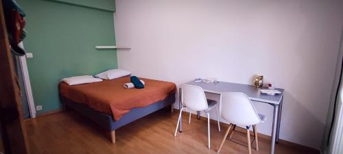 une petite pièce avec un lit, une table et des chaises dans l'établissement SuiteZy 3 chambres Rennes Sud, à Rennes