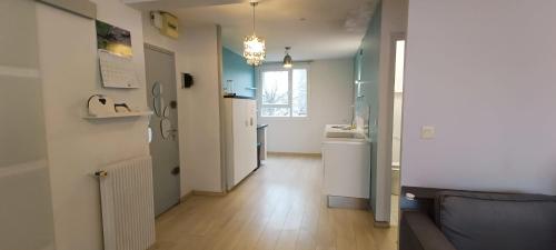 un salon avec un canapé et une cuisine dans l'établissement SuiteZy 3 chambres Rennes Sud, à Rennes