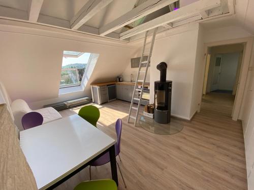 a room with a table and chairs and a stove at Rheinblick ESER Luxury Apartments in Rheinfelden