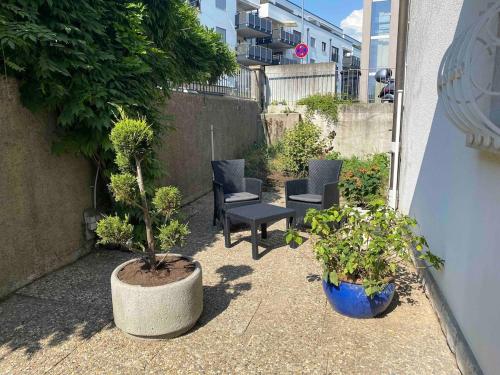 a patio with chairs and potted plants next to a building at Rheinblick ESER Luxury Apartments in Rheinfelden