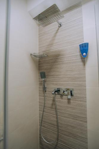 a shower with a faucet in a bathroom at White Blue Ohrid - Luxury Apt, City Center, Private Parking, Balcony, near Ohrid Lake in Ohrid