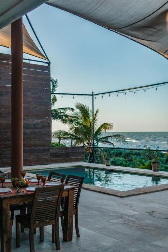 a patio with a table and chairs next to a swimming pool at Casa Ceballos, Frente a la Playa in San Benito