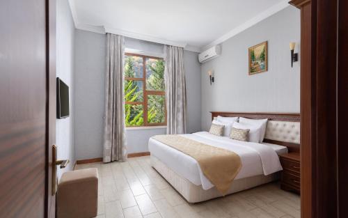 a bedroom with a large bed and a window at Shamakhi Palace Sharadil in Şǝrǝdil