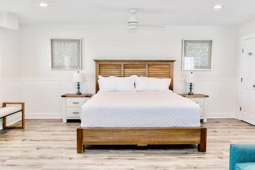 a white bedroom with a large bed and two tables at 3008 King Suite, 3rd Floor Serenity in Surf City