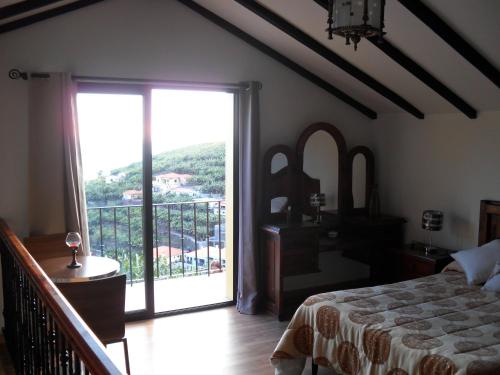 a bedroom with a bed and a large sliding glass door at Fazenda do Sousinha in Funchal