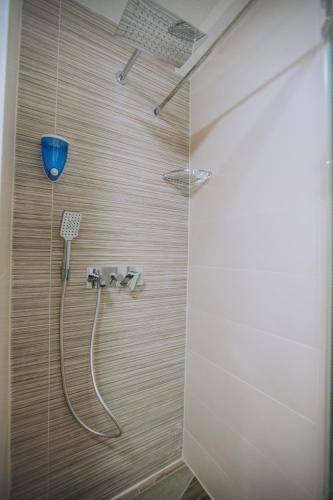 a bathroom with a shower with a blue bucket at White Blue Ohrid - Luxury Apt, City Center, Private Parking, Balcony, near Ohrid Lake in Ohrid