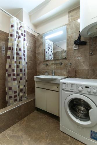 a bathroom with a washing machine and a sink at Sea View Apartments MonteBook in Becici