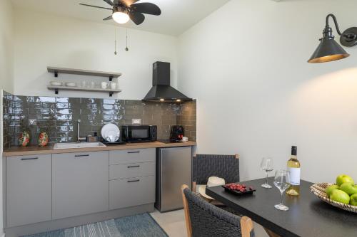 a kitchen with white cabinets and a dining table at THALASSA VIEW RESIDENCE in Argostoli