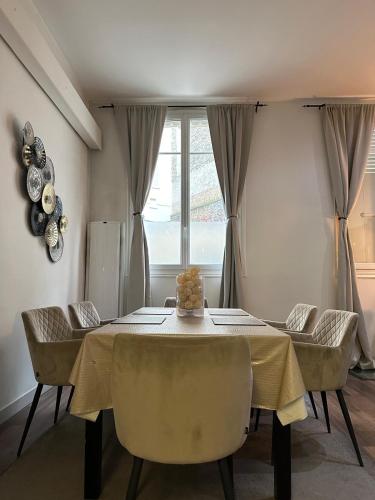 une salle à manger avec une table et des chaises et une fenêtre dans l'établissement Les Champs Elysées-125m2 Modern and Spacious, à Paris