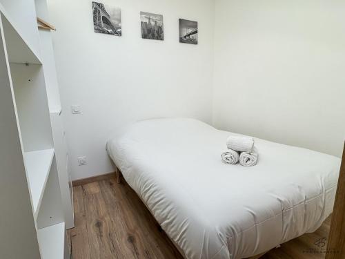 a bedroom with a bed with two cameras on it at Le Repaire de Leucate - Confort près de la Plage in Leucate-Plage