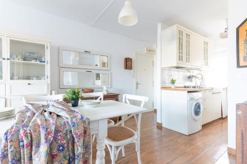 una cucina e una sala da pranzo con tavolo e sedie bianchi di Acogedor apartamento junto a la playa a Suances