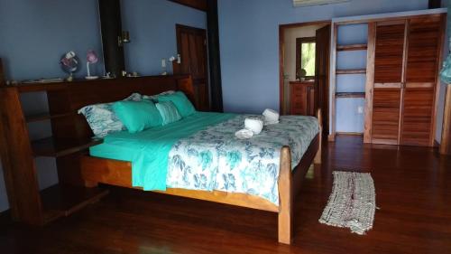 a bedroom with a bed with a green comforter at Bocas Beachfront Lodge Spacious Corner King Suite Ocean View Sand Level in Bocas del Toro