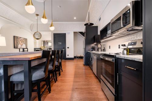 a kitchen with a long counter and some chairs at The Mayfair in New Orleans