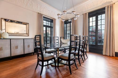 a dining room with a table and chairs and a mirror at The Mayfair in New Orleans