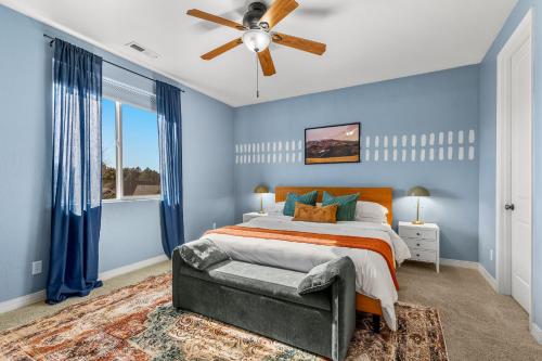 a blue bedroom with a bed and a ceiling fan at Cozy 4BR Near Ski Resort - Firepit & Pool Table in Flagstaff