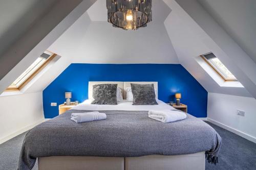 a bedroom with a large bed with a blue wall at 4br-sleeps8-privategarden-freeparking in Nottingham