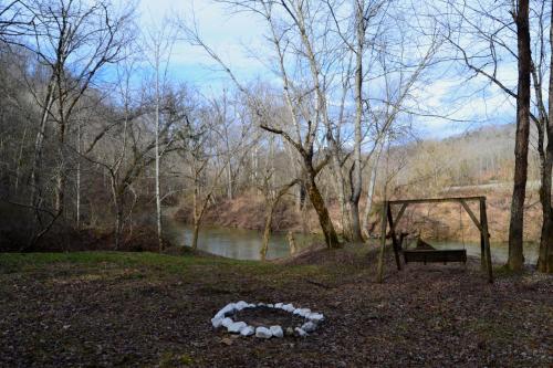 a circle of white rocks on the ground next to a bench at Restful River Cabin, Red River Gorge, KY, River Access & Views in Stanton
