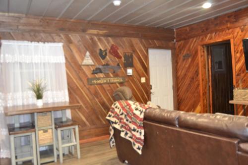 a living room with a leather couch and wooden walls at Restful River Cabin, Red River Gorge, KY, River Access & Views in Stanton