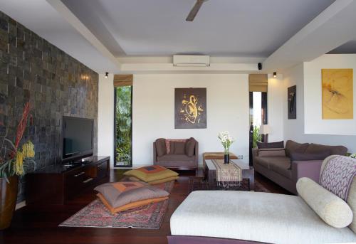 a living room with a couch and a tv at Temple Hill Residence Villa in Jimbaran