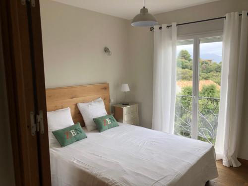 une chambre avec un lit et une grande fenêtre dans l'établissement Bella vista, à Lumio