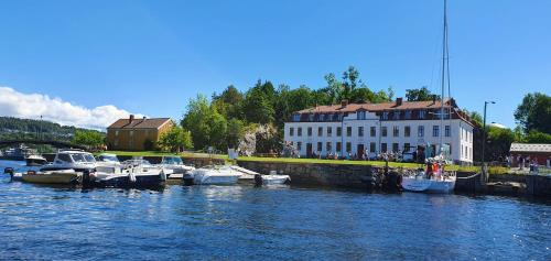 a group of boats docked in the water near a building at Villa Thorse in Husvik