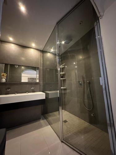 une salle de bain avec une douche en verre et un lavabo dans l'établissement Les Champs Elysées-125m2 Modern and Spacious, à Paris