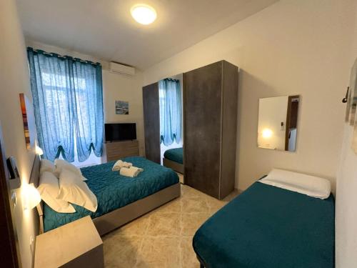 a hotel room with two beds and a mirror at The Travelers House in Civitavecchia